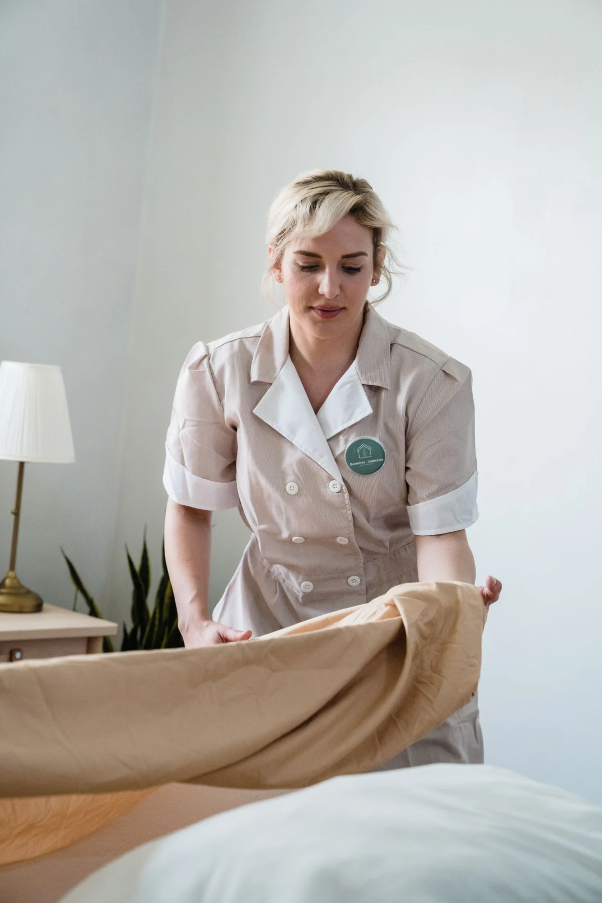 Professional housekeeper making a bed
